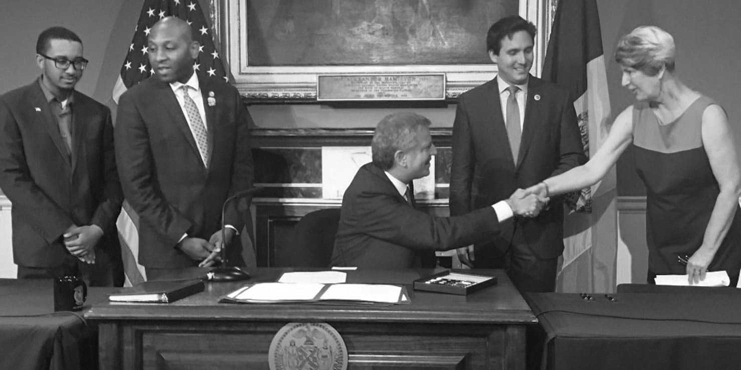 Elizabeth Goldstein and Bill deBlasio shake hands at signing of Board of Standards and Appeals reform bills