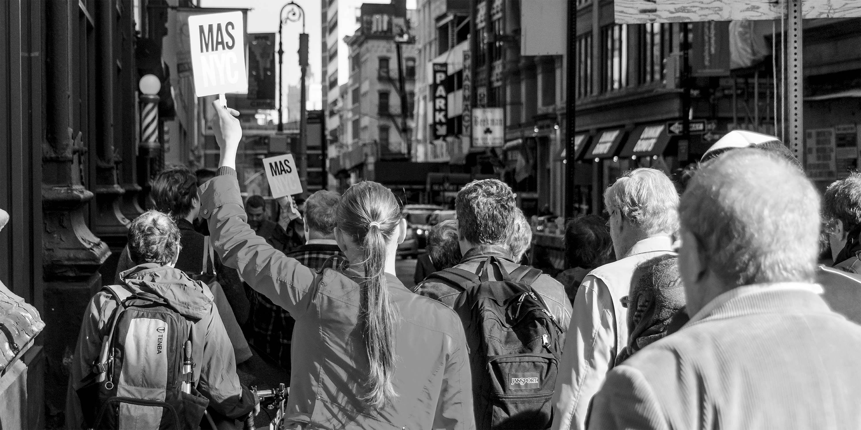 guide leads a tour group and holds a Municipal Art Society of New York sign