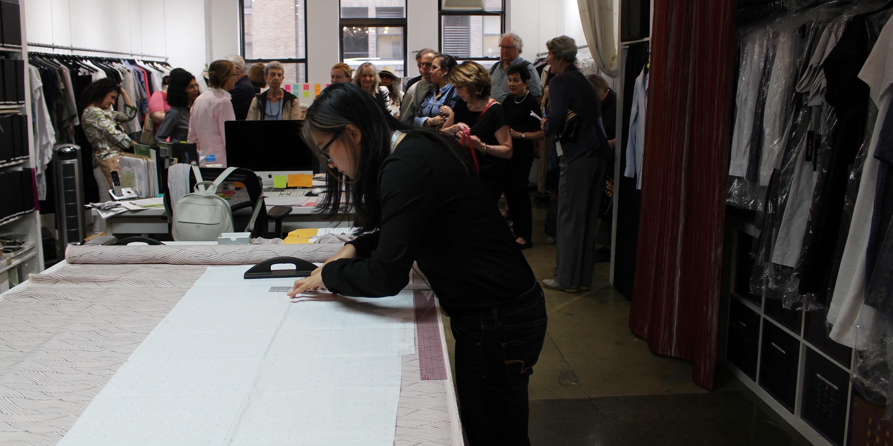 worker measures cloth at a shop in the Garment District