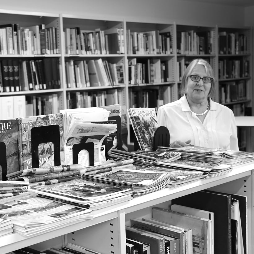 librarian with books in the Greenacre Reference Library