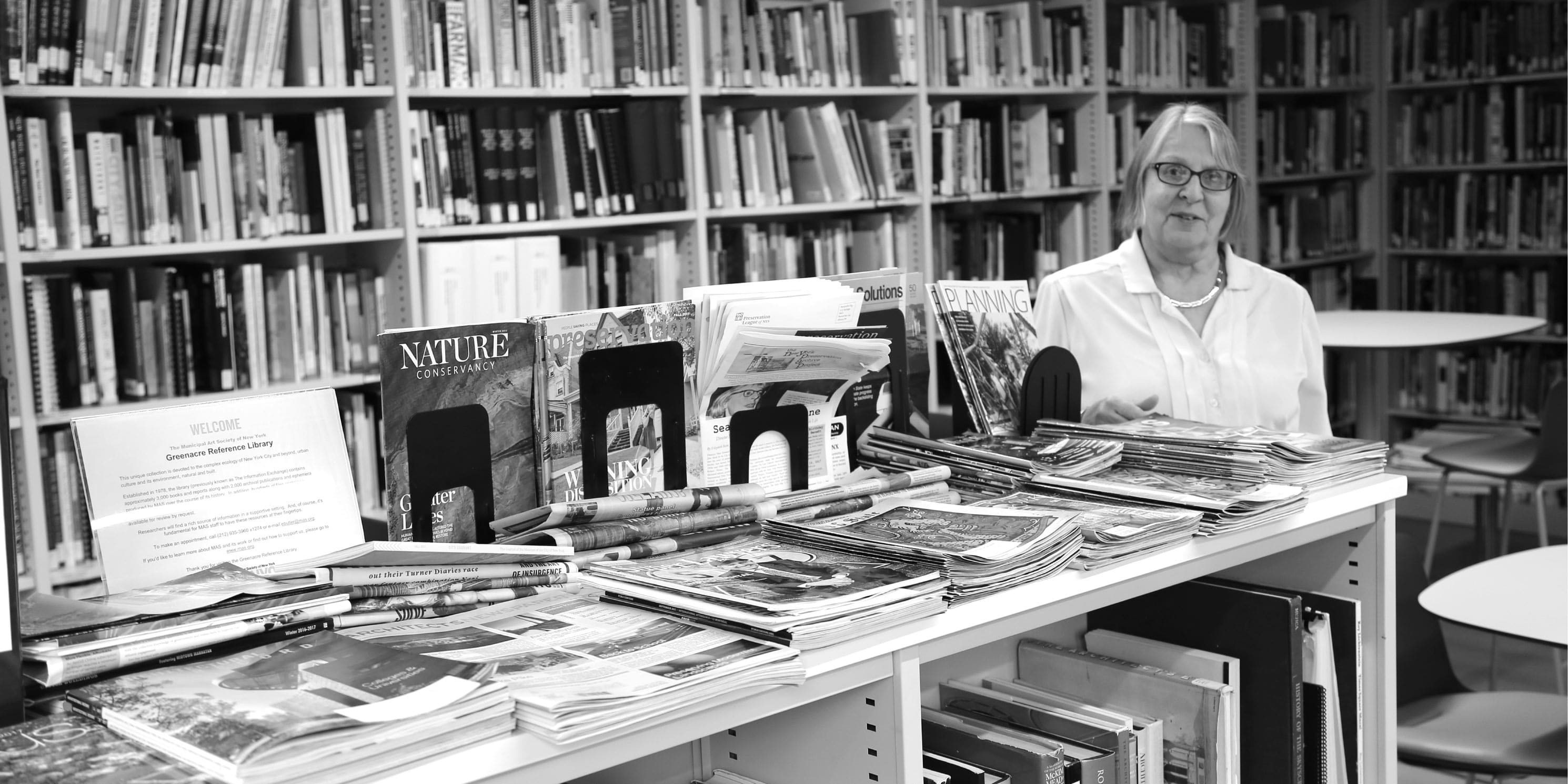 librarian with books in the Greenacre Reference Library