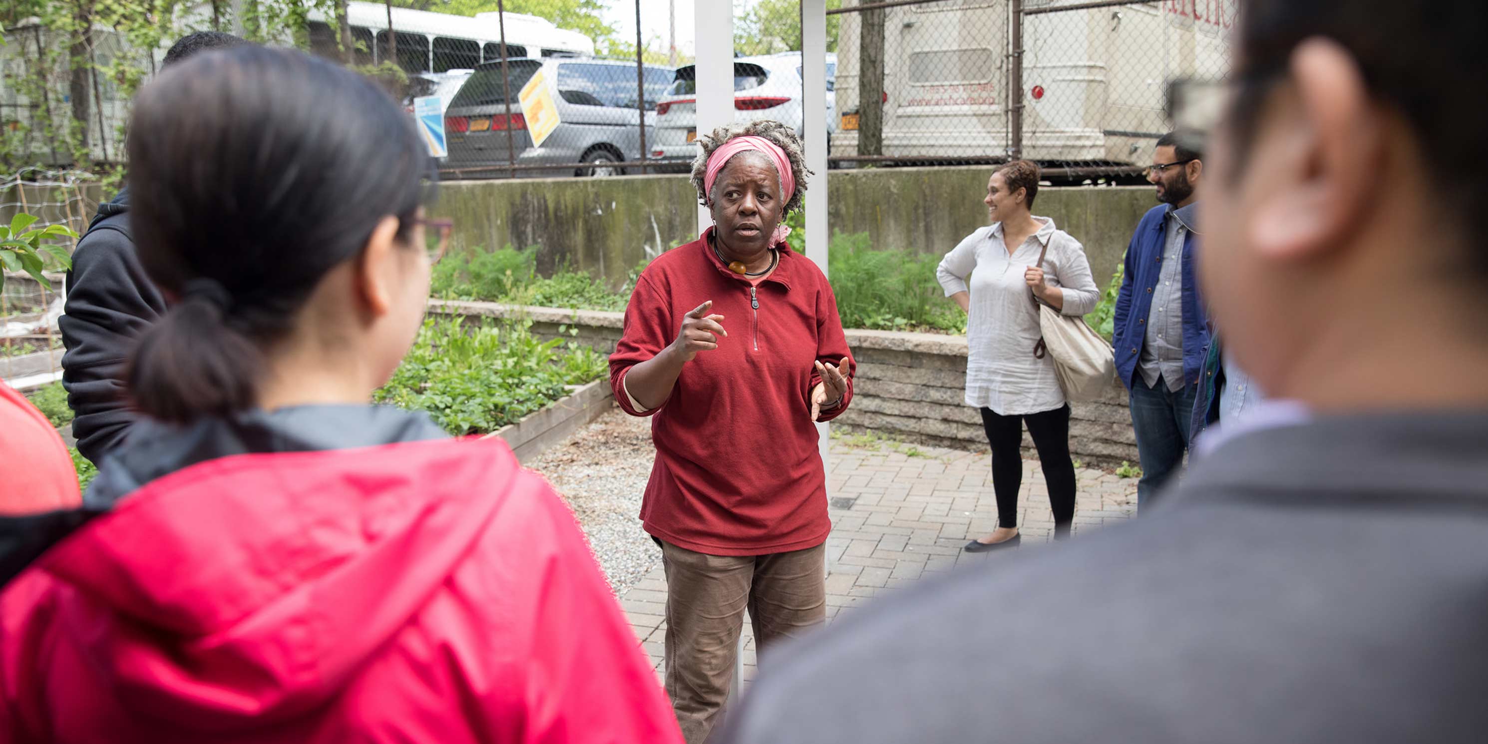 leader speaks during a Jane's Walk at a community garden