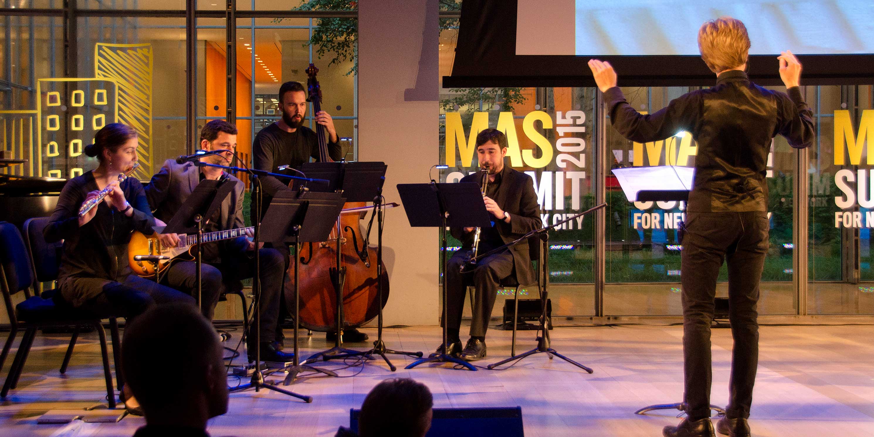 Musicians perform on stage at the Summit