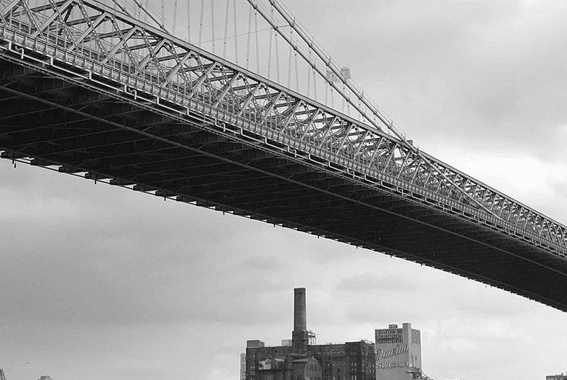 Williamsburg Bridge with the Domino Sugar Refinery in the background. Photo: Wikimedia Commons, Joe In Queens.