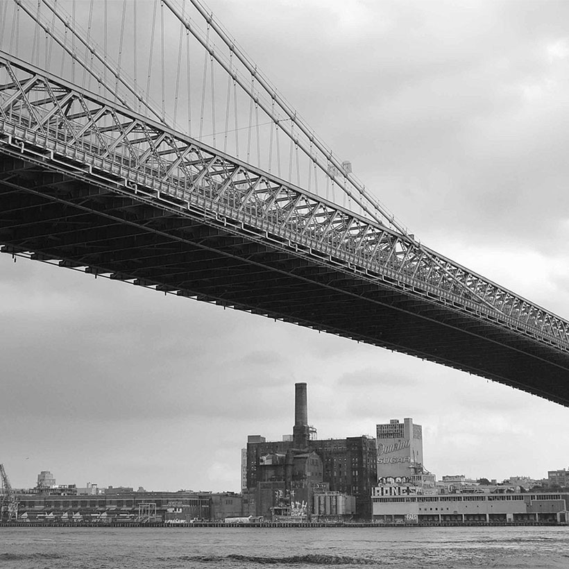 Williamsburg Bridge with the Domino Sugar Refinery in the background. Photo: Wikimedia Commons, Joe In Queens.