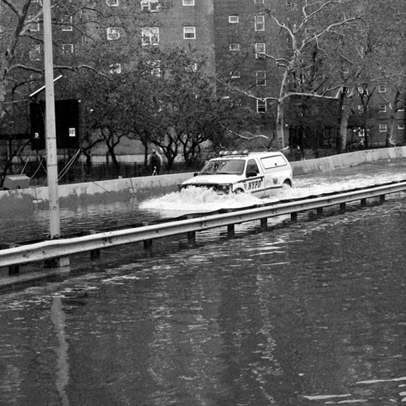 A NYPD van drives down the FDR flooded from Hurricane Sandy in 2012