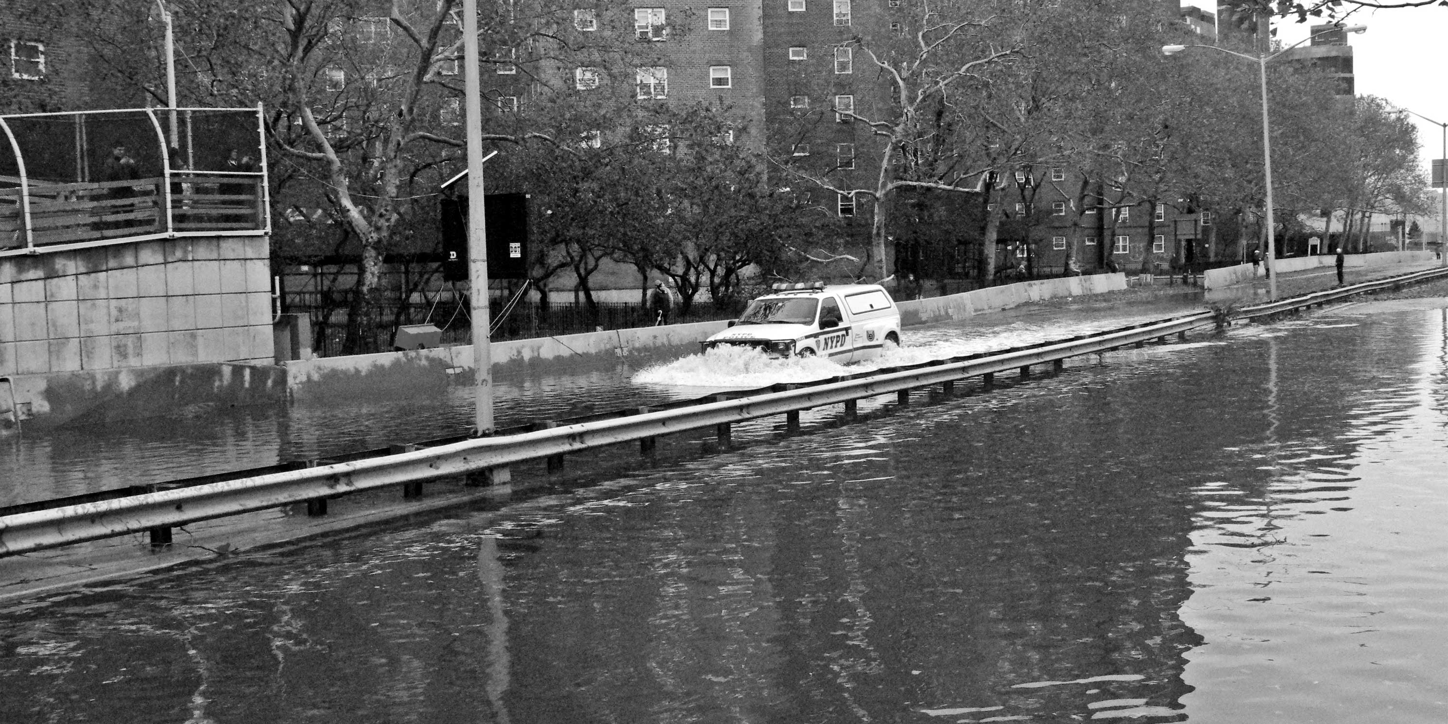 A NYPD van drives down the FDR flooded from Hurricane Sandy in 2012