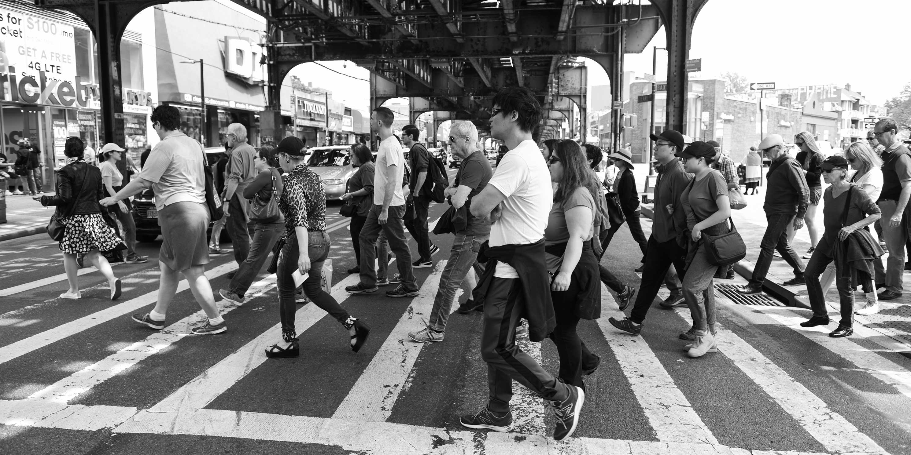 people on a Jane's Walk cross Roosevelt Avenue