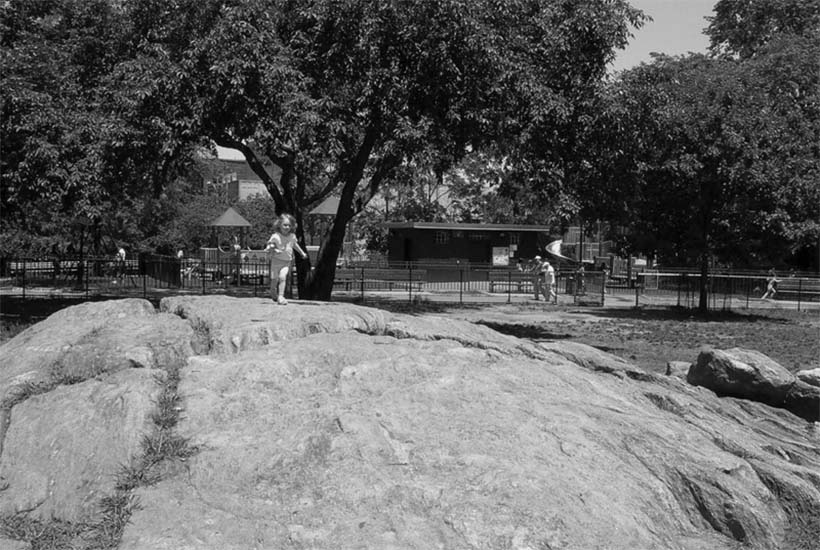 Child climbing rock in Bennett Park