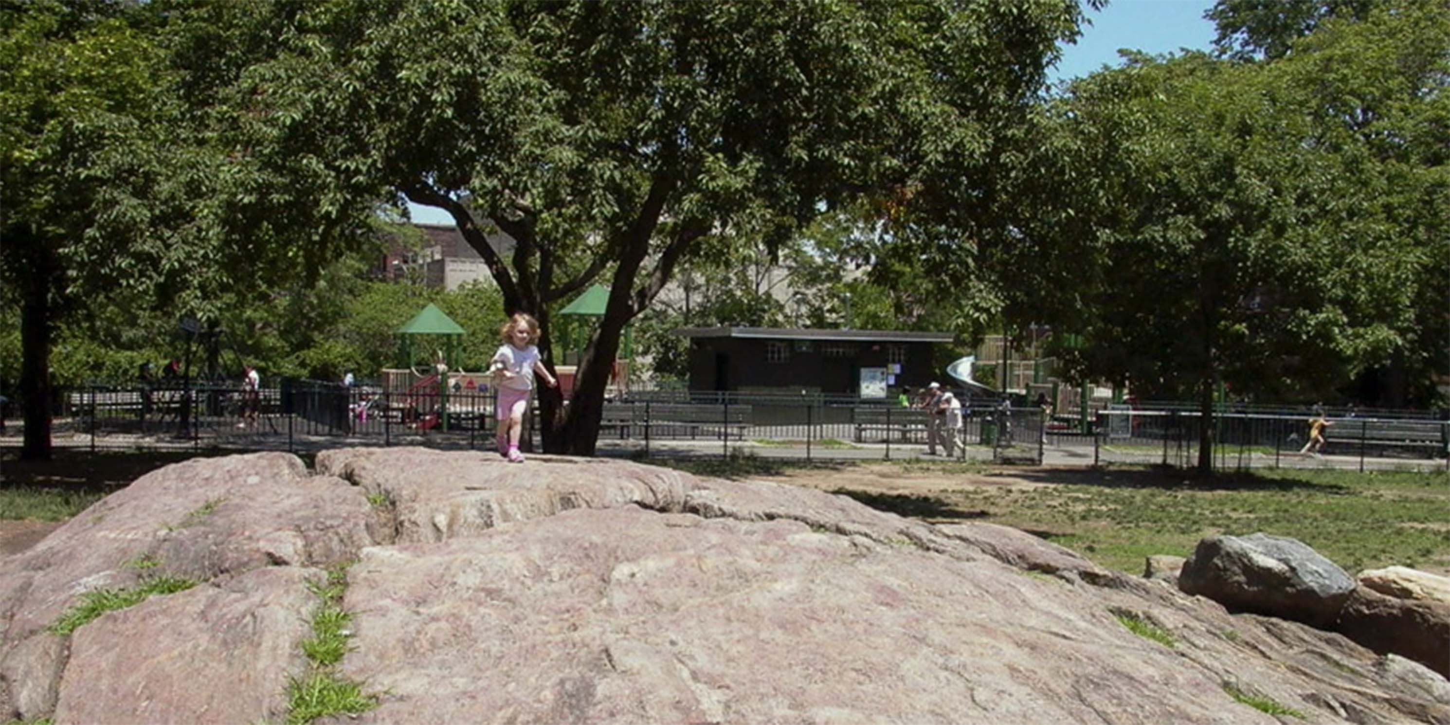 Child climbing rock in Bennett Park