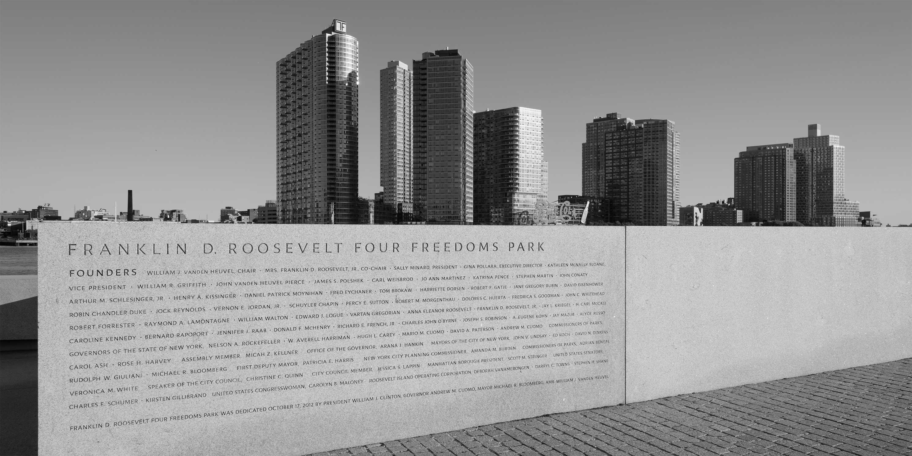 Wall with names of park founders on it at Four Freedoms Park. Long Island City can be seen in the background.