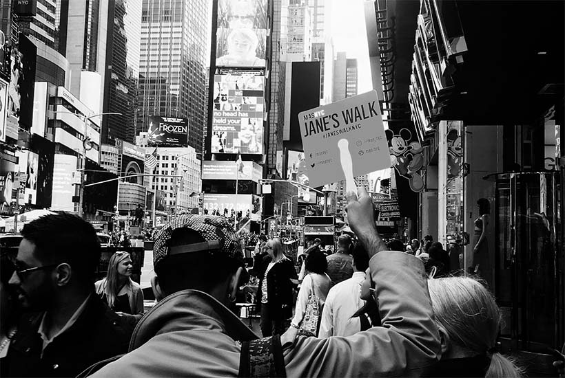 leader holds sign on Jane's Walk in Times Square