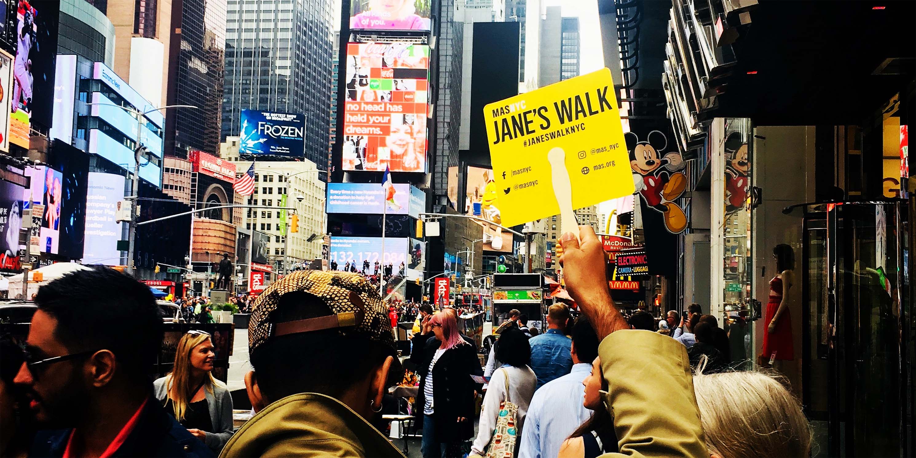 leader holds sign on Jane's Walk in Times Square