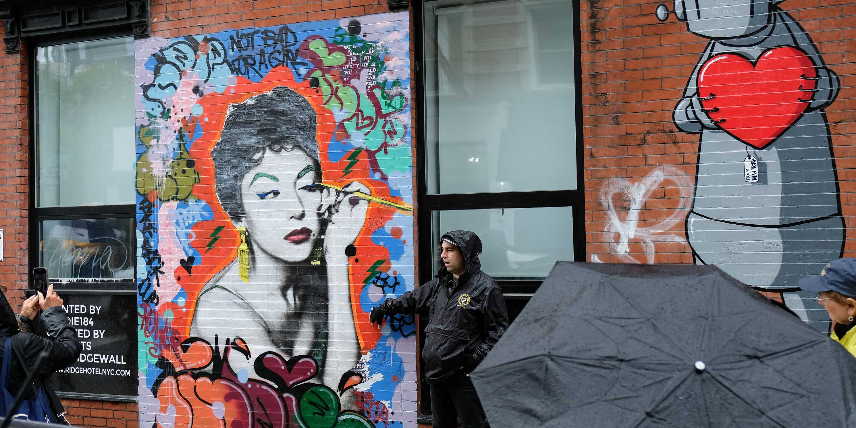 walkers in front of mural