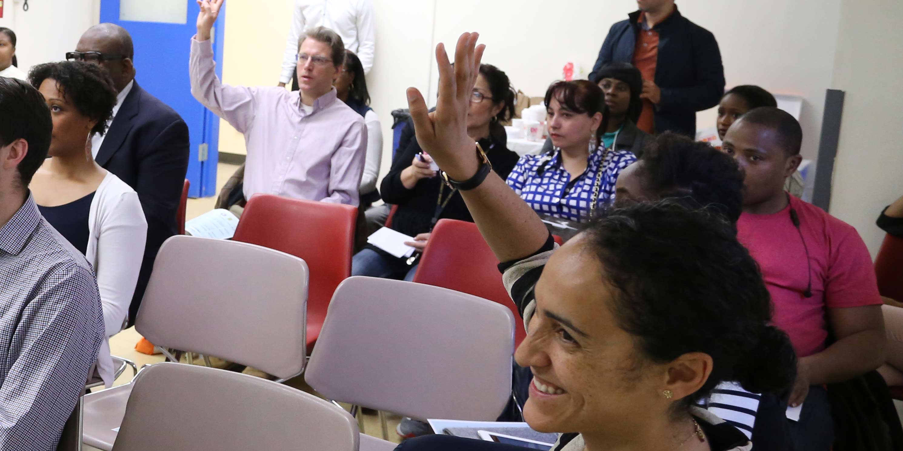 people raise hands at workshop