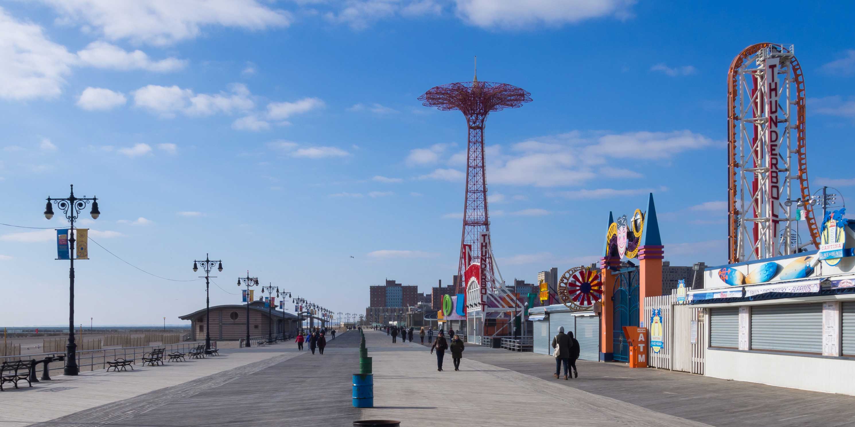 People walk the Riegelmann Boardwalk in Coney Island