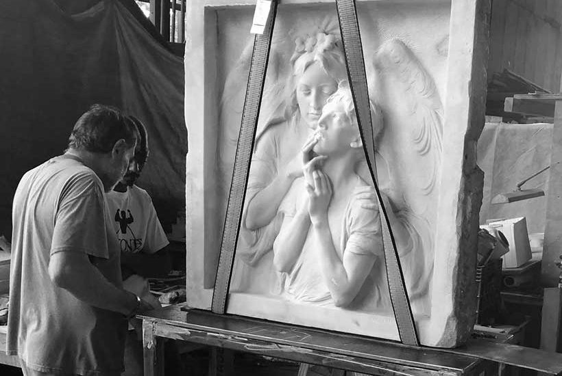 workers in a workshop stand near the restored Rebecca Salome Foster Memorial