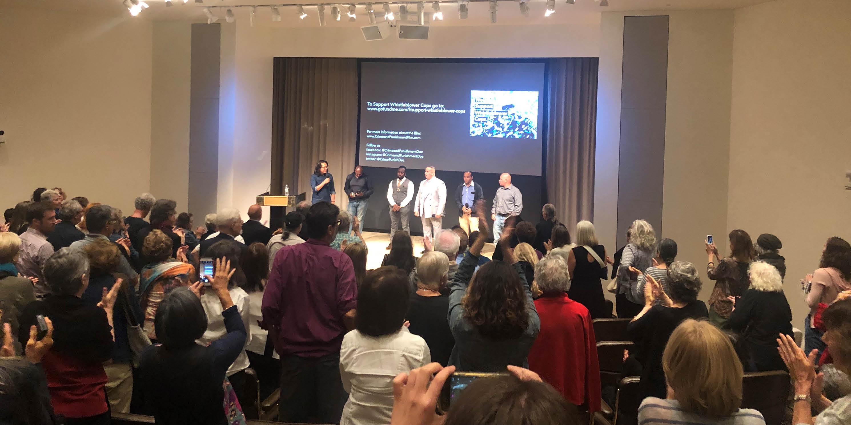 director and cast members on stage as audience applauds, during a screening of the movie Crime and Punishment