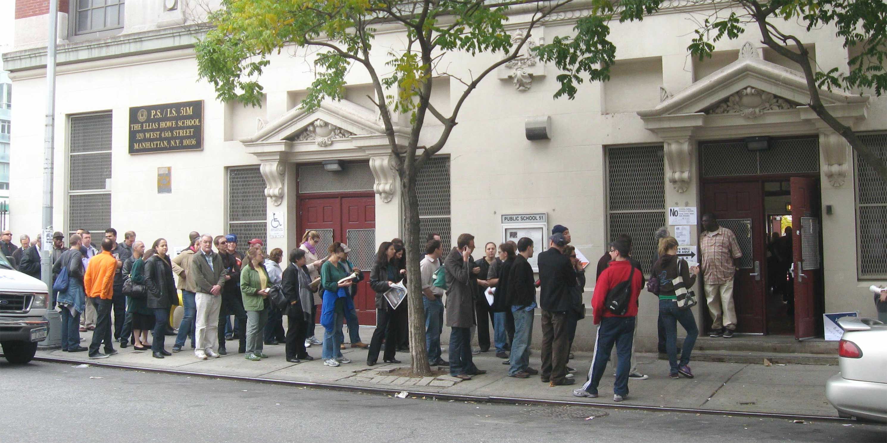 line of people waiting outside school to vote