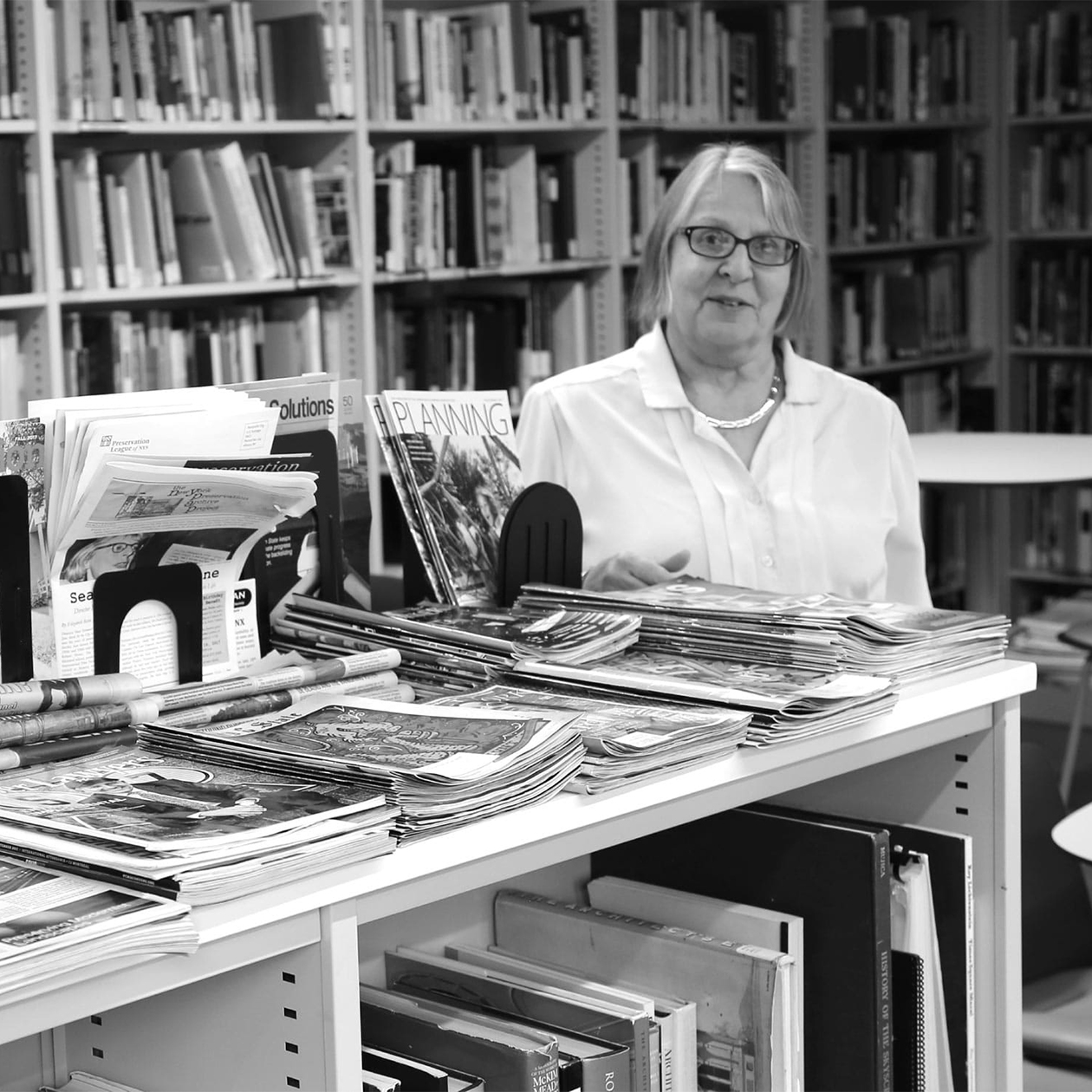 librarian with books in the Greenacre Reference Library