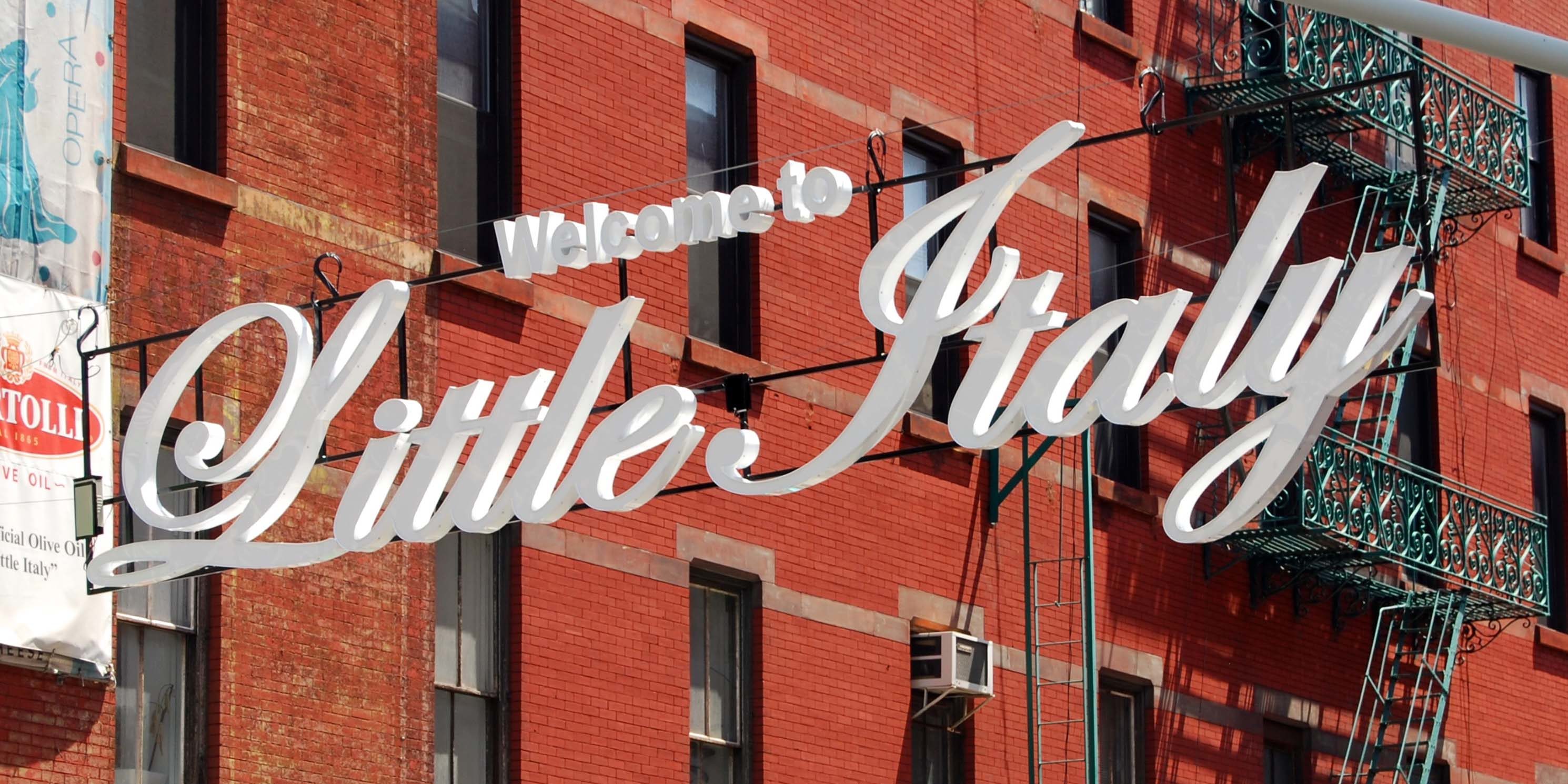 Welcome to Little Italy sign hangs across the street in Little Italy, New York City