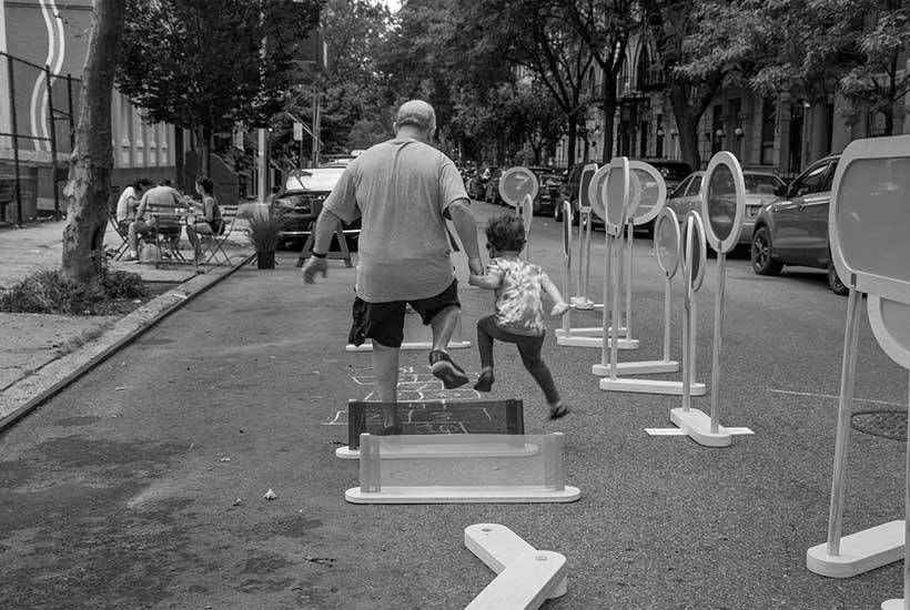 a father and child play on 101st Street in East Harlem during an Open Streets event