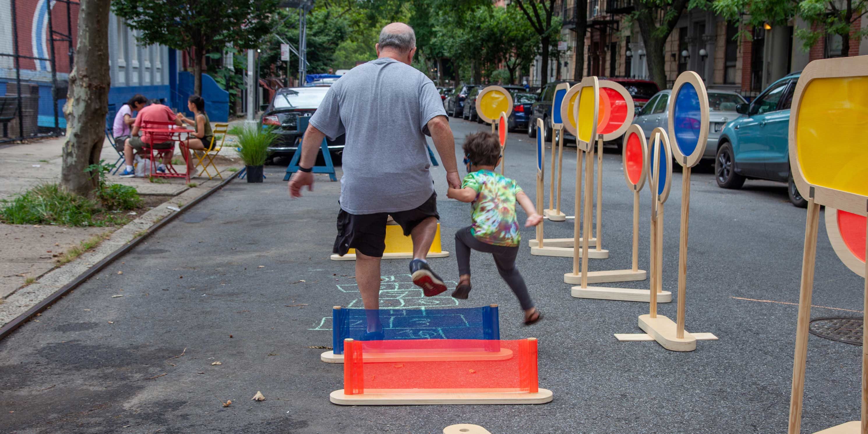 a father and child play on 101st Street in East Harlem during an Open Streets event