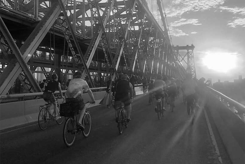 bicyclists ride across bridge in New York City