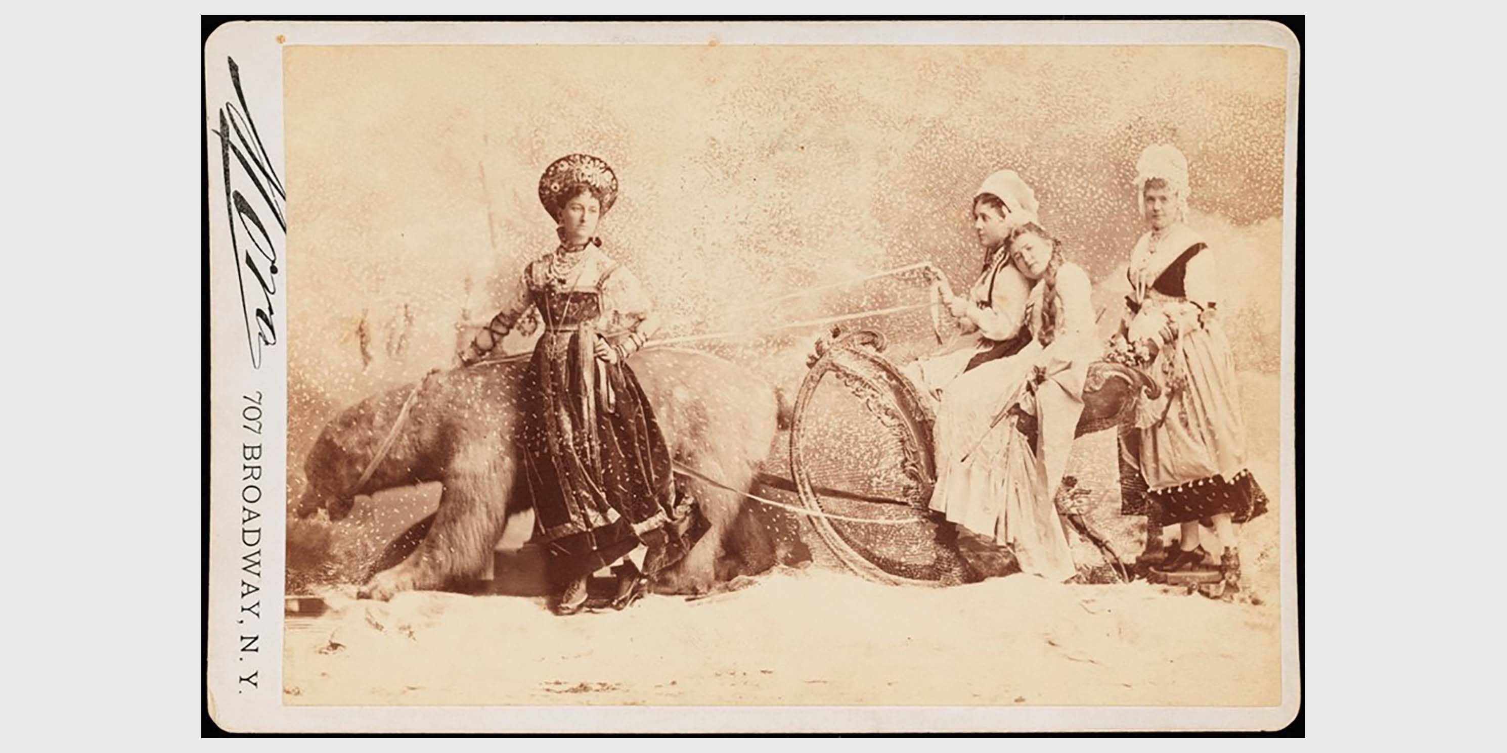 young women pose with bear at the Jose Maria Mora Studio in New York City around 1875