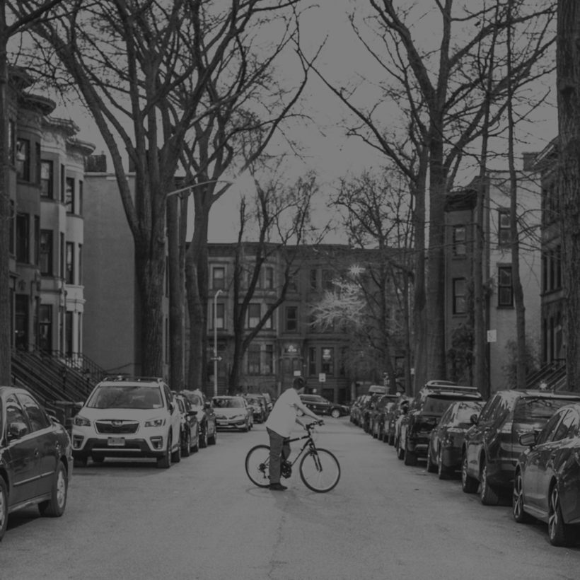 man rides bike on quiet street in Park Slope, Brooklyn