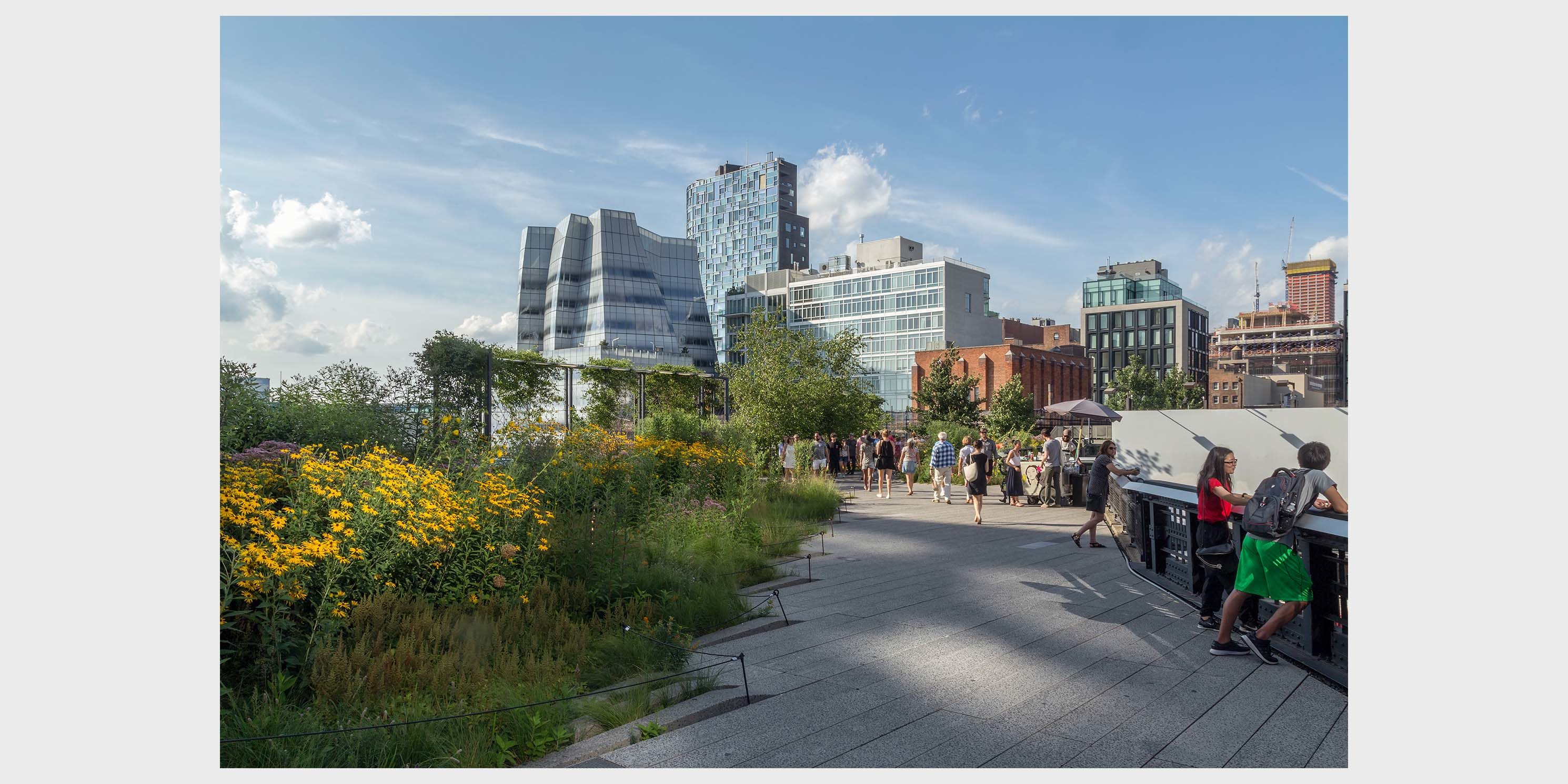 people stroll the Highline with IAC building in background