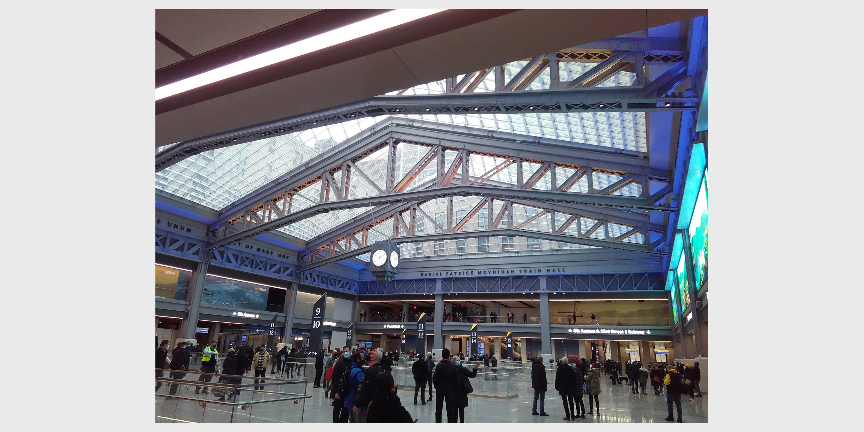 passengers stand inside the Daniel Patrick Moynihan Train Hall in Manhattan